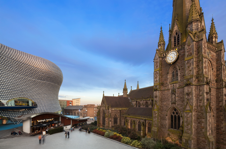 A silver-domed building on the left with a clock tower on the right.