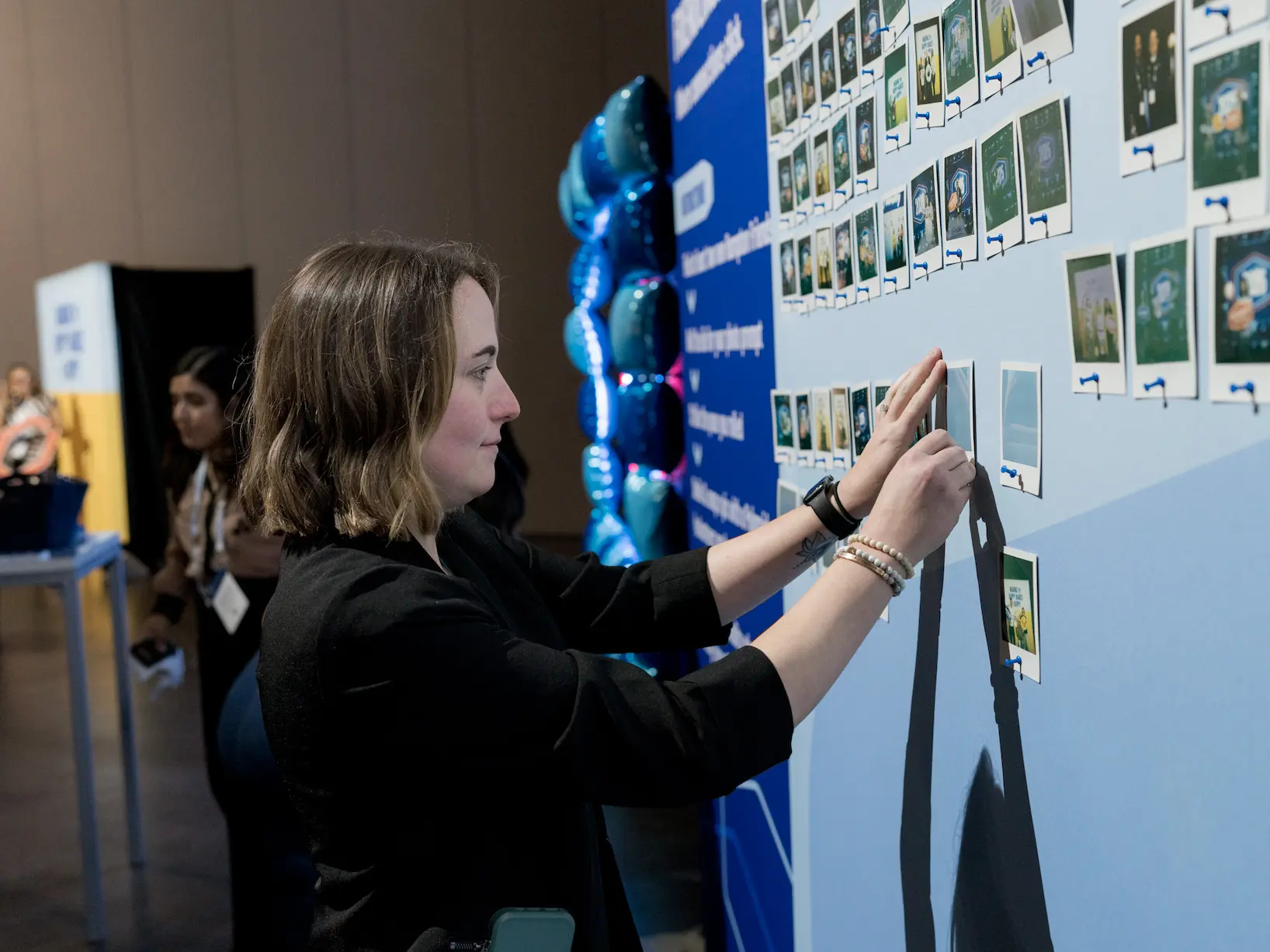 woman placing photos on the board
