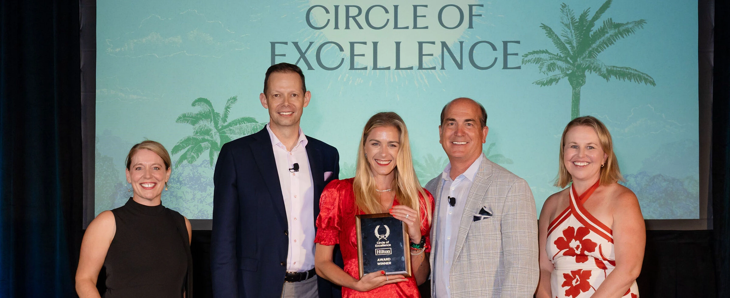 Hilton attendees on stage holding an award