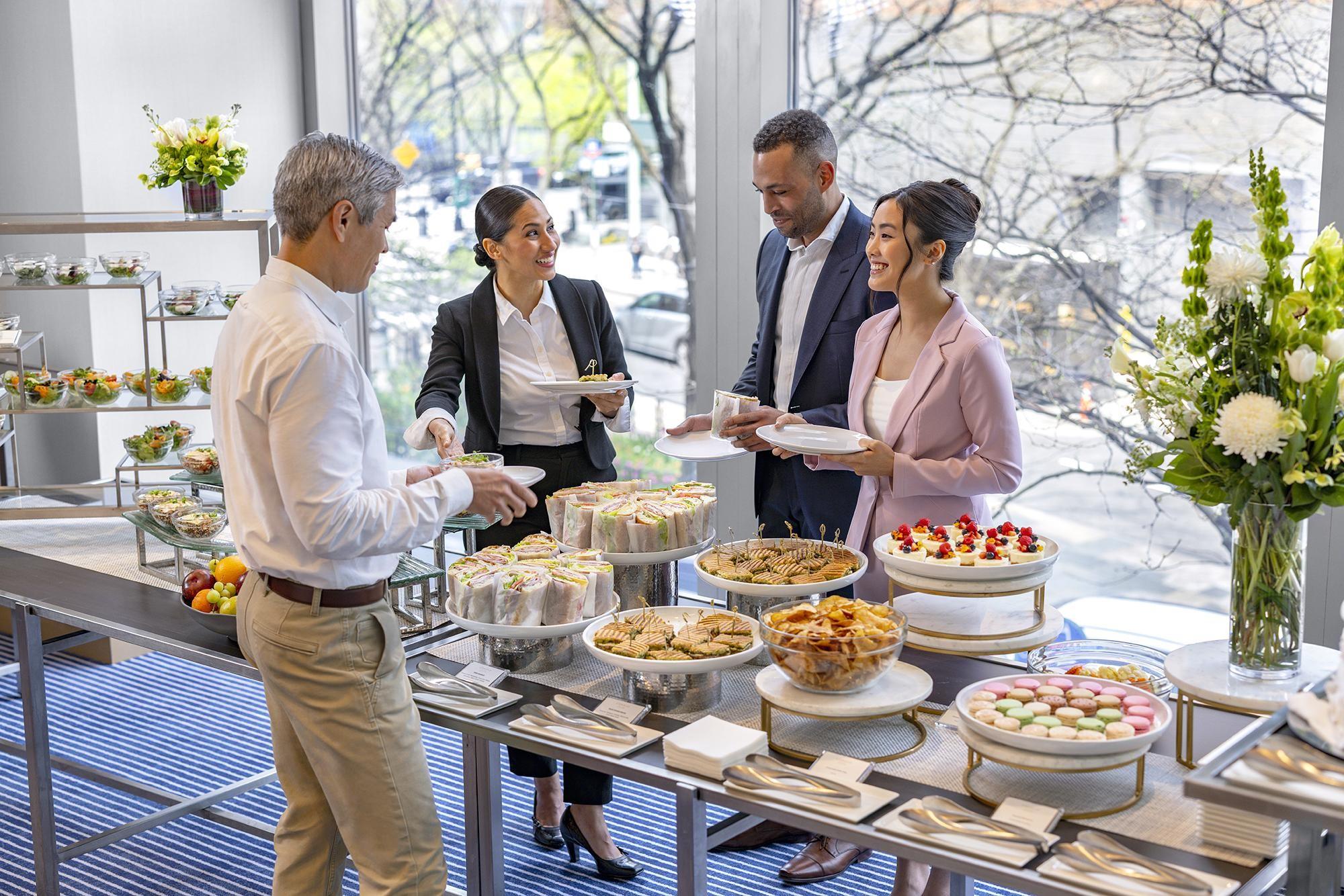 Happy people meeting at a buffet line