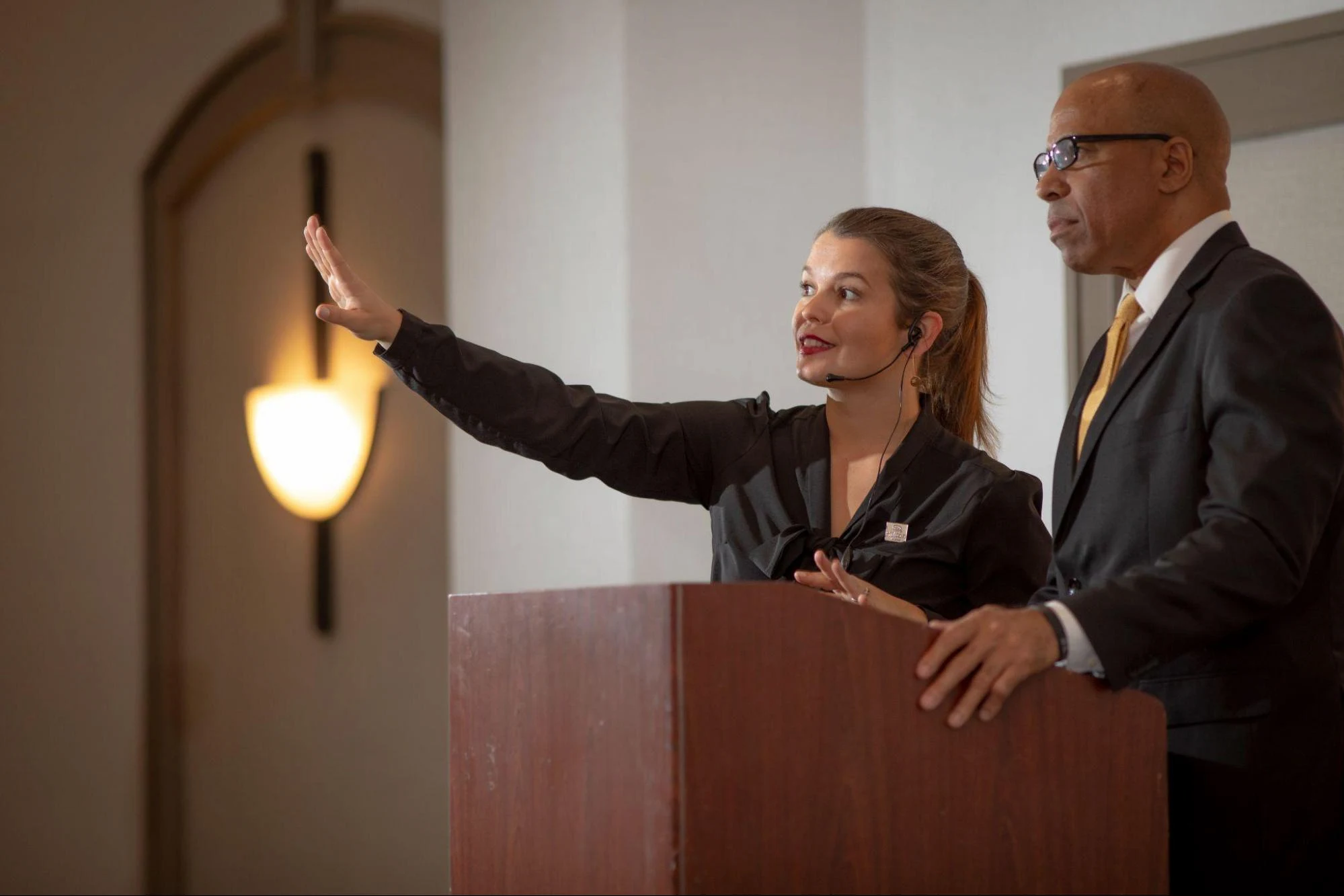 Two people standing by the podium