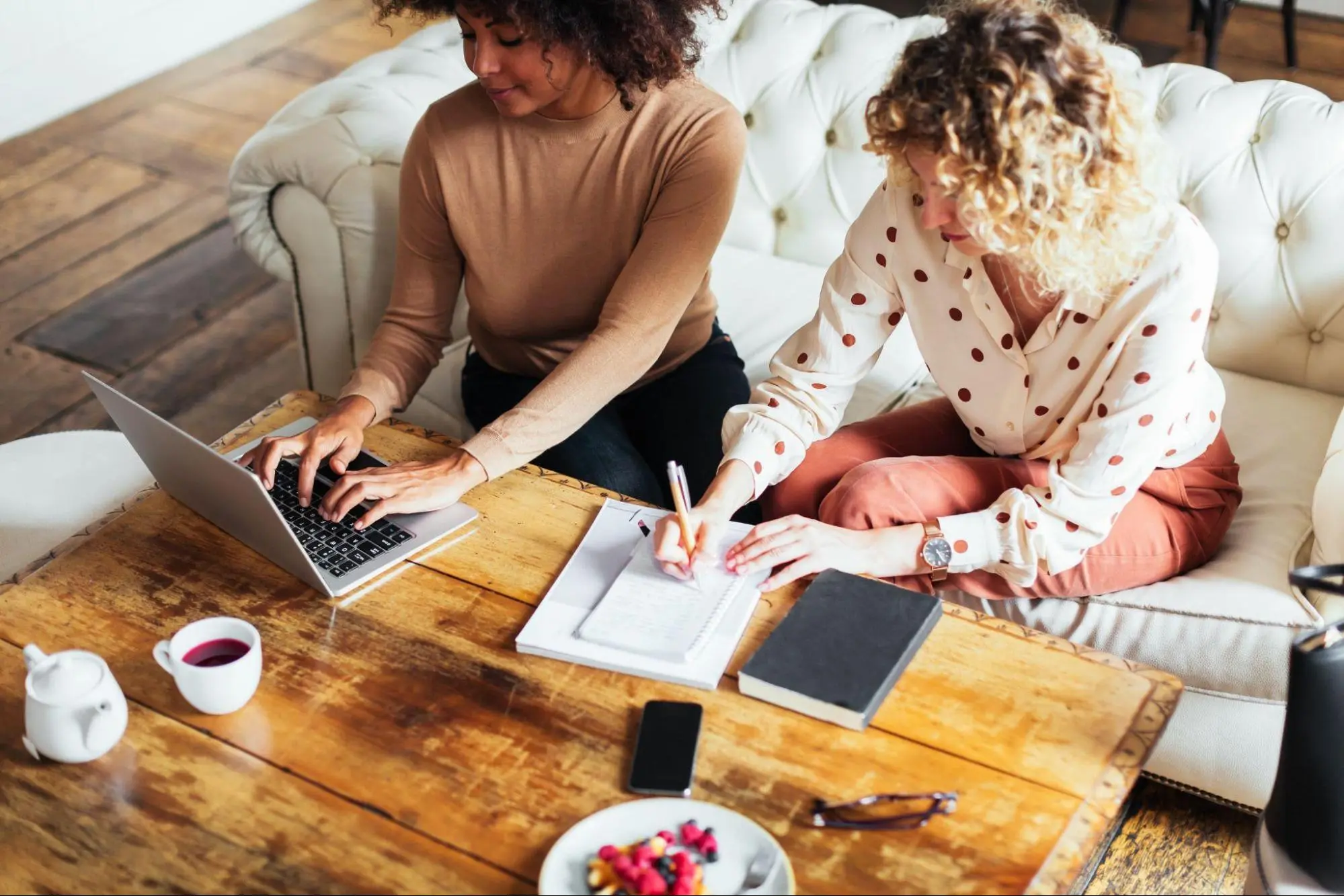 Two women working by the coffee table
